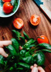 Lifestyle photo of cooking healthy eating with tomatoes and fresh spinach on a kitchen table