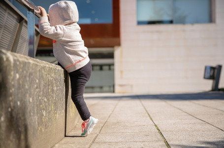 Little girl with sneakers and hoodie training outdoors