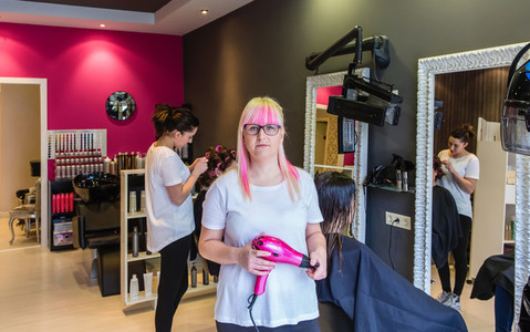 Woman hairdresser standing in hair and beauty salon