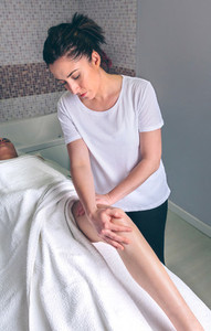 Massage therapist doing lymphatic drainage treatment to woman
