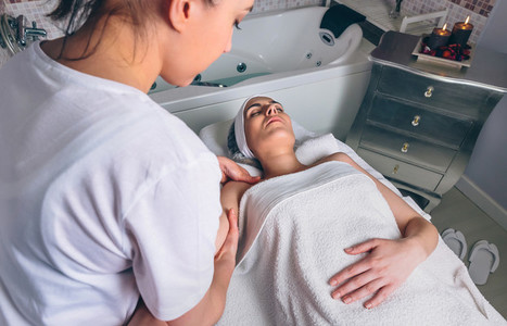 Massage therapist doing lymphatic drainage treatment to woman