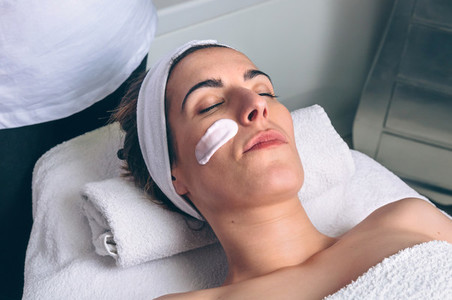 Woman lying with facial mask treatment in spa
