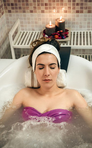 Woman lying in tub doing hydrotherapy treatment