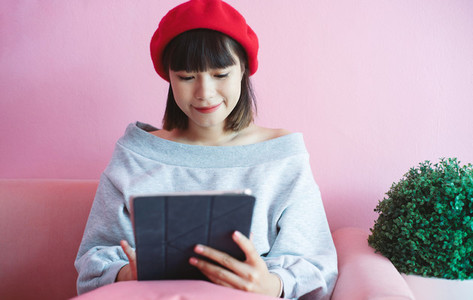 Young happy asian millennial woman using digital tablet at the p