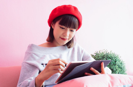 asian millennial woman using and writing digital tab