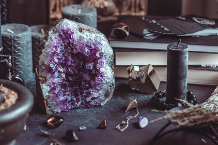 Amethyst Druze on a witchs altar for a magical ritual among crystals and black candles