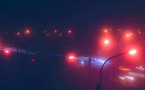 Neon lights of night city and motion traffic in fog  Retro colored image
