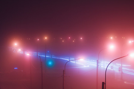 Neon lights of night city and motion traffic in fog  Retro colored image