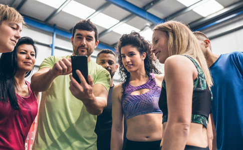 Athletes looking at the mobile of a gym mate