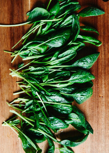 Top view of fresh spinach leaves on a wooden cutting board  Healthy vegetarian eating concept