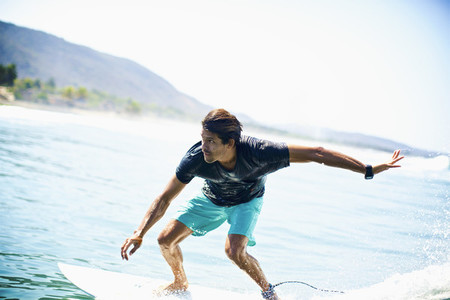 Focused male surfer riding ocean wave