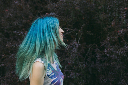 Profile carefree young woman with blue hair