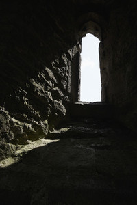 Sunlight streaming through stone arch window  England
