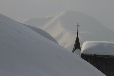 Church steeple rising among snowy mountain  Switzerland