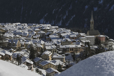 Scenic view sunny snow covered village rooftops Switzerland