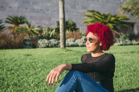 Woman with red hair relaxing in sunny park