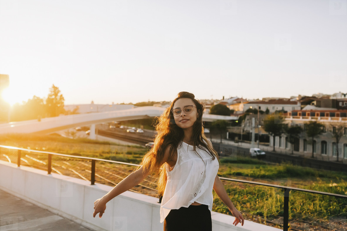 Portrait carefree young woman in sunny urban park