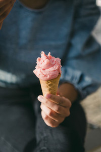 Close up woman eating pink ice cream cone
