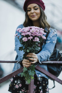 Portrait young woman holding purple flower bouquet