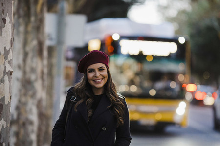 Portrait confident young woman in beret on urban sidewalk