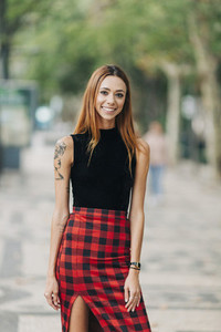 Portrait confident  stylish young woman in checked skirt