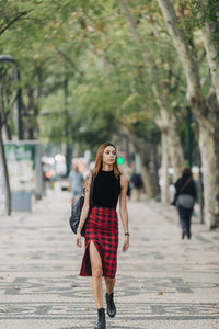 Stylish young woman walking in urban park