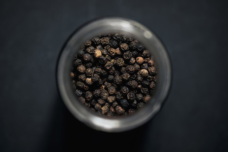 View from above black peppercorns in spice jar