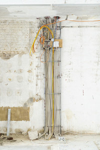 Cluster of wiring along wall at construction site