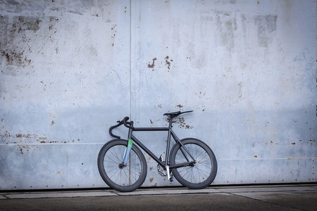 Racing bicycle leaning against concrete wall