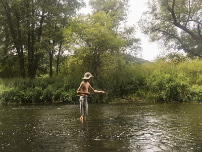 Boy fishing in rural river