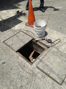 Worker under street manhole