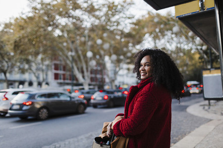 Smiling young woman on urban sidewalk