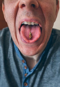 Man showing a cricket on his tongue