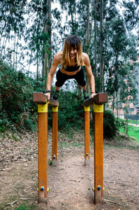 Athlete woman training on parallel bars