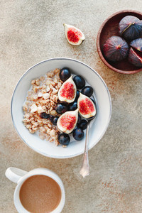 Top view of a breakfast bowl with granola blue grape and fig slices Healthy vegan eating flat lay