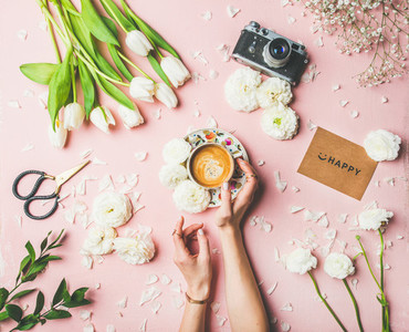 Female hands holding coffee  flowers  film camera and sign happy