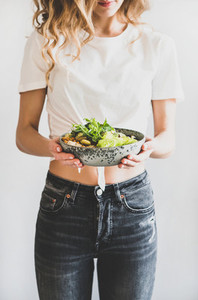 Woman holding healthy vegan superbowl in hands