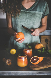 Woman making fresh blood orange juice or smoothie