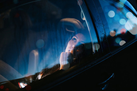 Young woman inside a car looking away through the window