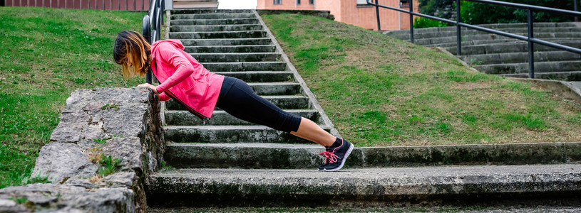 Female athlete doing push ups outdoors