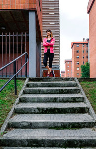 Female athlete posing up stairs outdoors