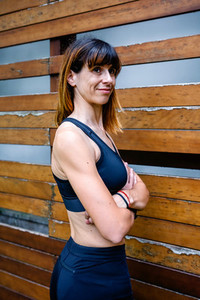 Cheerful female athlete in front of a wooden background