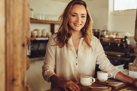 Smiling female barista serving coffee
