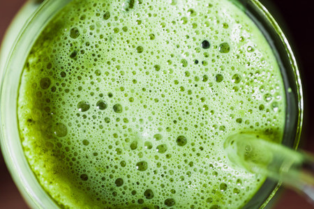 Top macro view matcha green tea latte in a glass jar with glass tube  Healthy clean eating concept