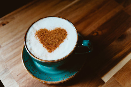 Cup of cappuccino coffee decorated cinnamon heart symbol  The concept of Valentines day and morning