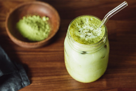 Matcha green tea latte in a glass jar with glass tube  Healthy clean eating concept