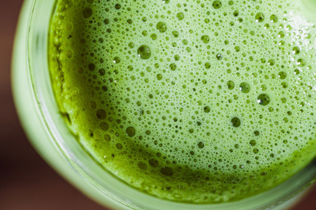Top macro view matcha green tea latte in a glass jar with glass tube  Healthy clean eating concept
