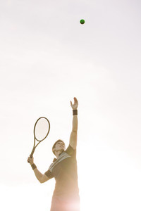 Tennis player serving a ball