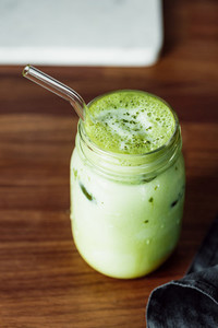 Matcha green tea latte in a glass jar with glass tube Healthy clean eating concept