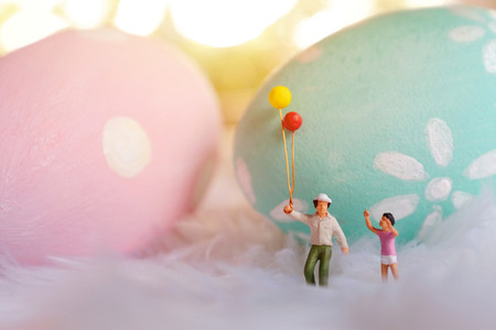 Miniature people family holding balloon with pastel and colorful